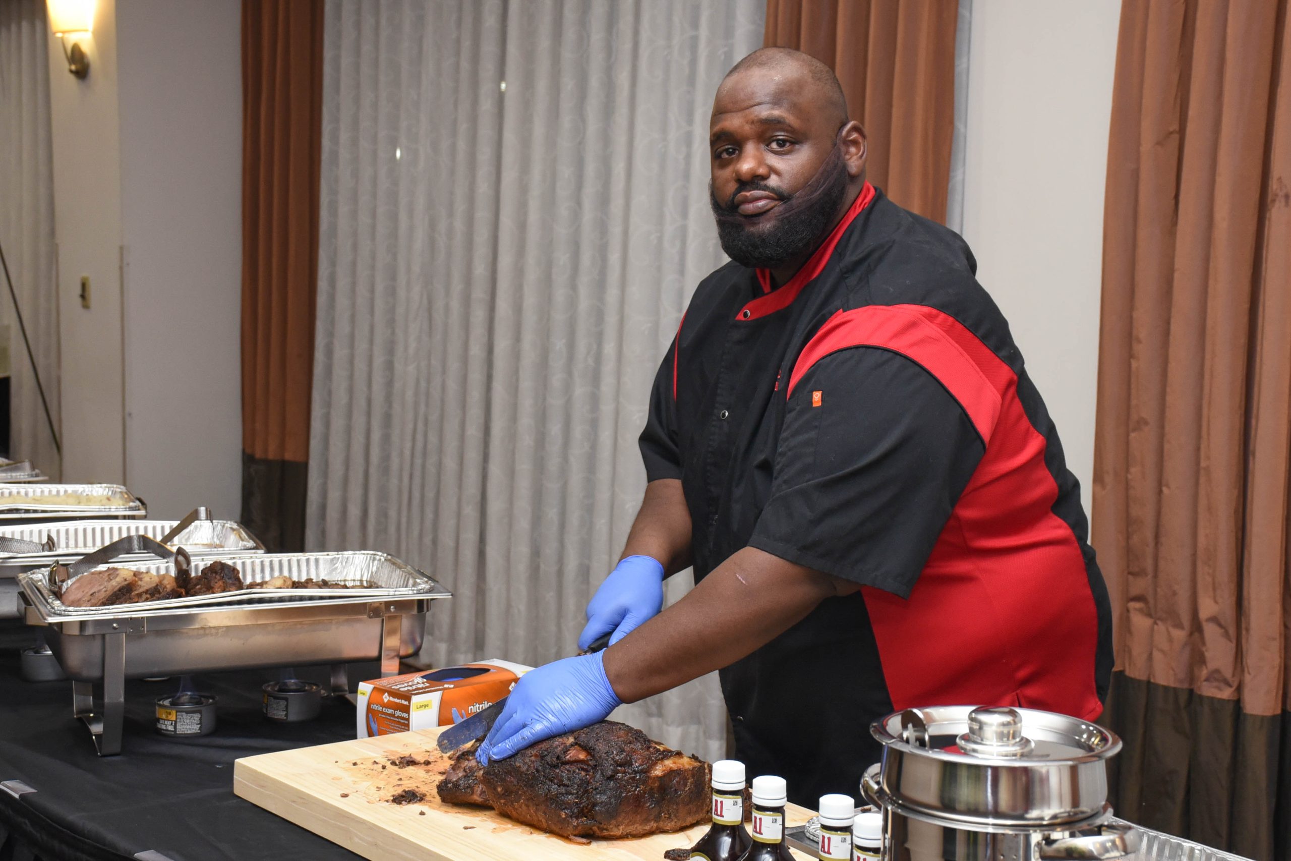 Chef Benny serving brisket at an event